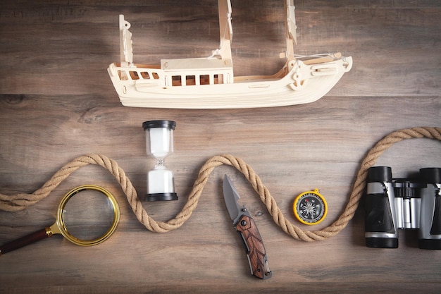 Wooden toy ship, compass, rope, binoculars, magnifying glass, hourglass, knife. Travel