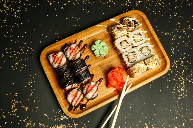 Wooden Tray Topped With Sushi and Chopsticks