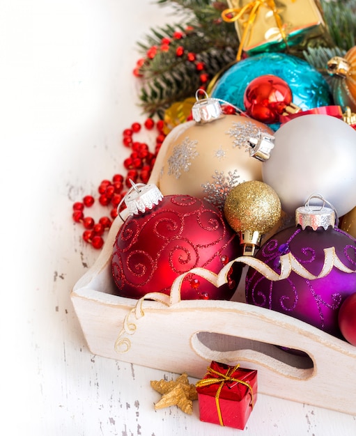 Wooden tray with Christmas decorations on white wood close up with copy space