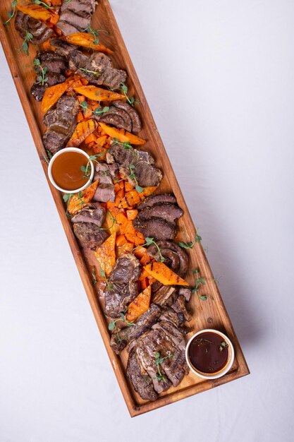 Wooden tray with delicious sliced beef and pumpkin