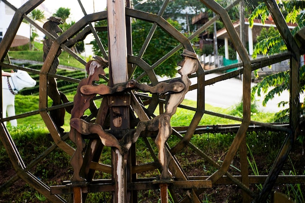 Wooden turbine baler or wood water wheels in creek canal for treatment water on pool pond at outdoor garden park at Wat Huay Pla Kang temple on sunset time in Chiang Rai Thailand