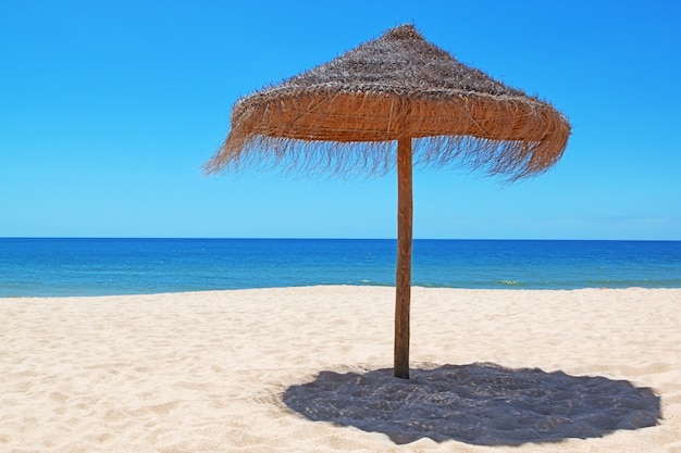 Wooden umbrella on the beautiful Portuguese beach.