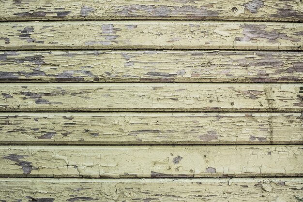 Wooden wall with cracked old green paint