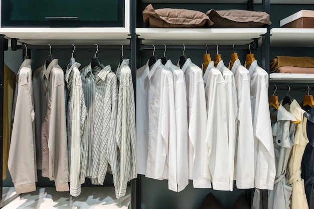 Wooden wardrobe in walk in closet with clothes hanging on rail