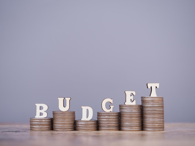 Photo wooden words with the budget on stack of coins the concept about budget planning and allocation