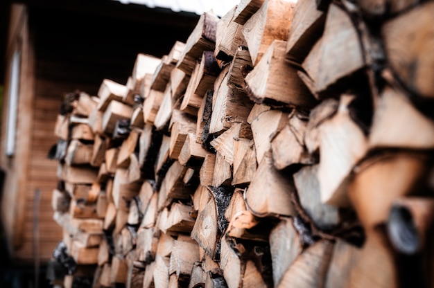 A woodpile with harvesting and stacked firewood of chopped wood for kindling and heating the house. firewood of the birch tree