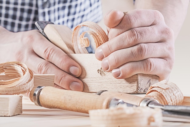 Photo woodworkers plane in hands of carpenter very close up