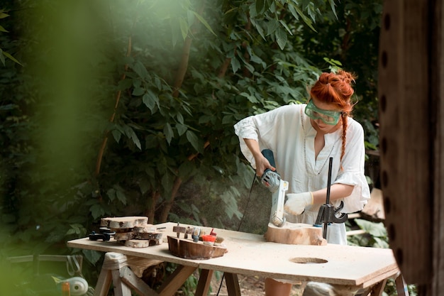 woodworking craftswoman female carpenter working outdoors in summer