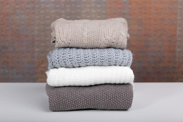 Wool sweaters on a white table with an industrial background