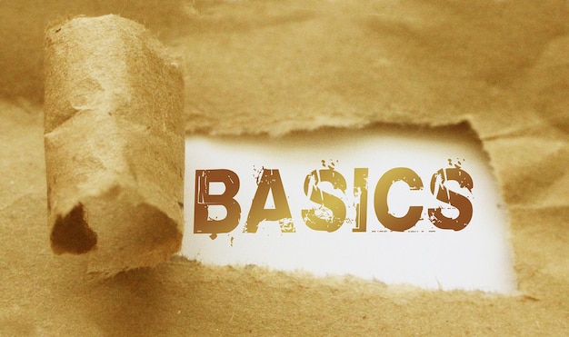 The word basics appearing behind torn brown paper Business learning concept