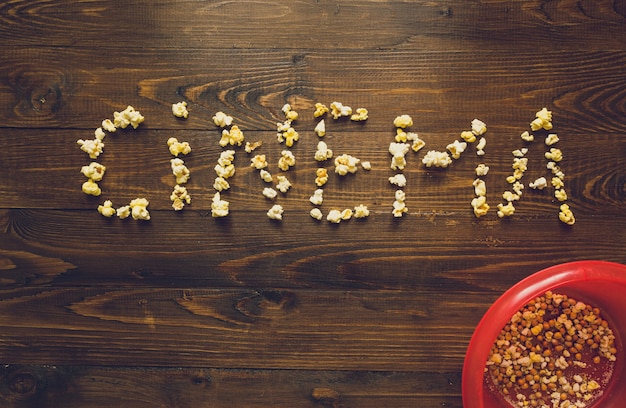 Word Cinema made of popcorn on old wooden desk