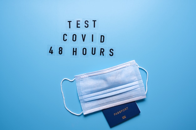 The word Covid test 48 hours on a blue background and a medical mask.