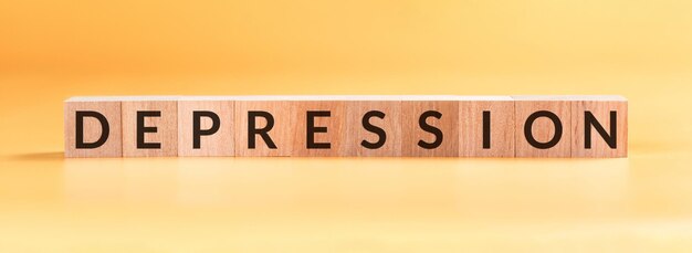 Word Depression written in wooden blocks on yellow background