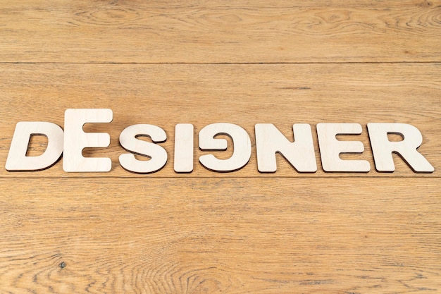 Word - designer, laid out in wooden letters on an old wooden table