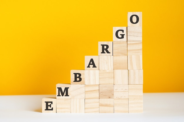 The word embargo is written on a wooden cubes. Corporate hierarchy concept and multilevel marketing.