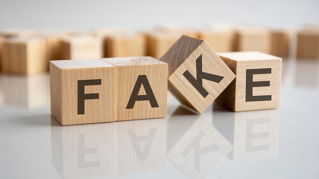 Word Fake on wooden cubes, gray background