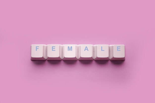 Word FEMALE written on computer keyboard keys isolated on a pink