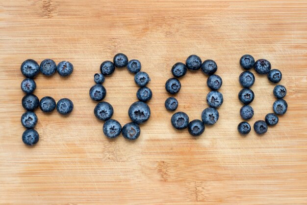 Word food formed with blueberries on wooden