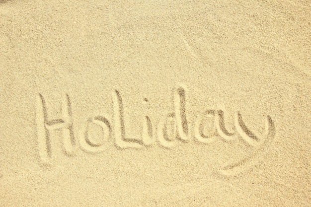 Word holiday inscription on the beach concept