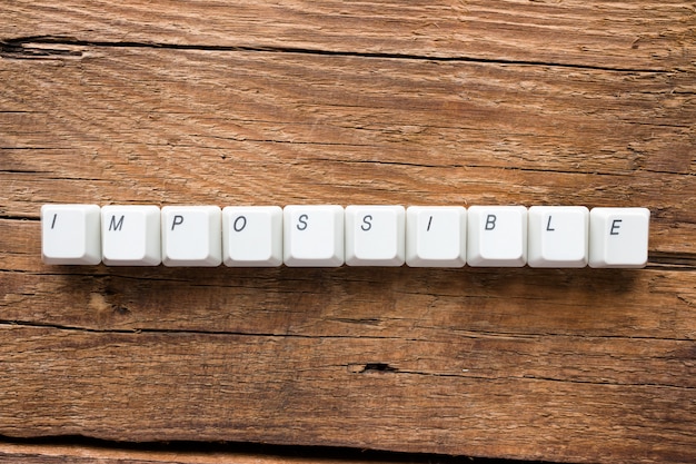 The word impossible of keyboard keys on wooden background