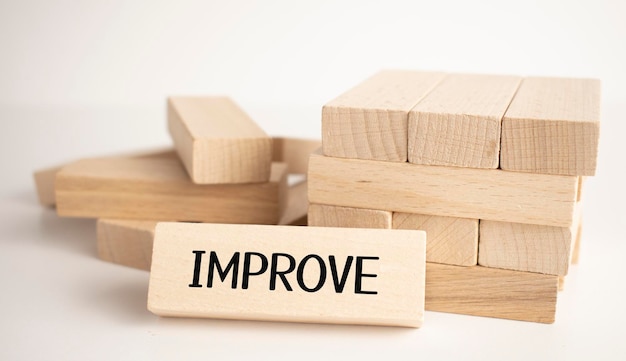 The word IMPROVE is made of wooden cubes on a violet background