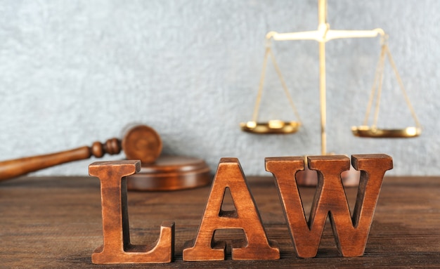 Word LAW made of wooden letters on table, closeup