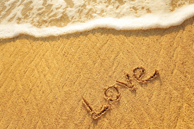 Word love written in the sand on the beach