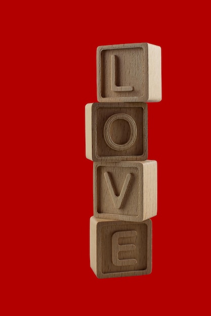 Word LOVE written vertically with cubes isolated on red background