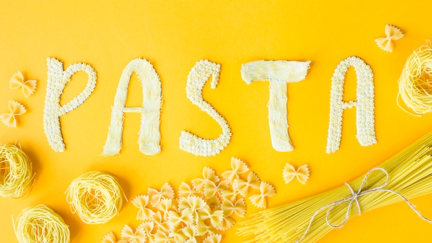 The word pasta is laid out in bulk letters from small raw macaroni 