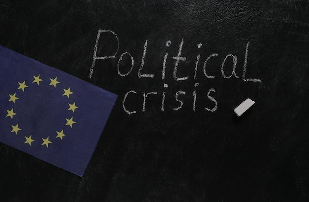 Word Political crisis chalk hand drawn on blackboard and EU flag