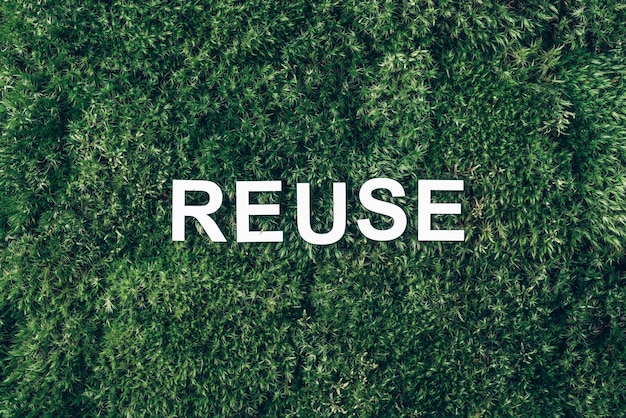 Word Reuse on moss green grass background Top view Copy space Banner Biophilia concept Nature backdrop