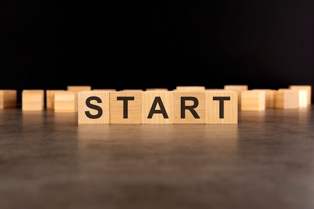 Word START written on wooden cube block stack on black background congratulation idea finance strategy business start up online marketing goal and target plan concept