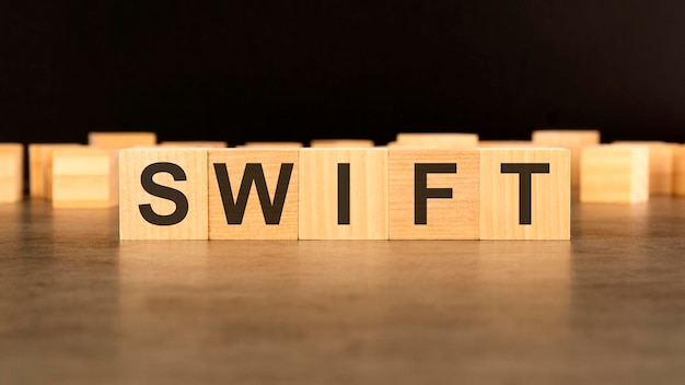 Word SWIFT written on wooden cube block stack on black background business concept