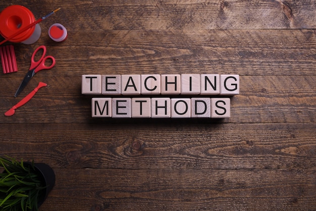 Word teaching methods on wooden cubes, blocks on the subject of education, development and training on a wooden table. Top view. 