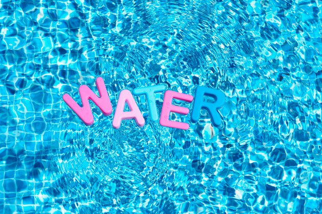 Word water in colors floating over a pool copy space