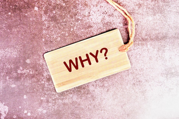 The Word Why written on a card that lies on a beautiful abstract background