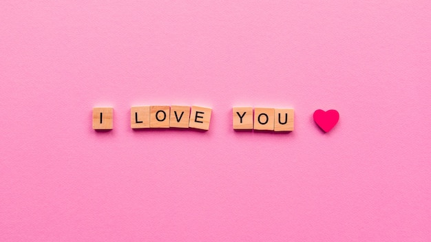 Words "I love you" on a pink paper.