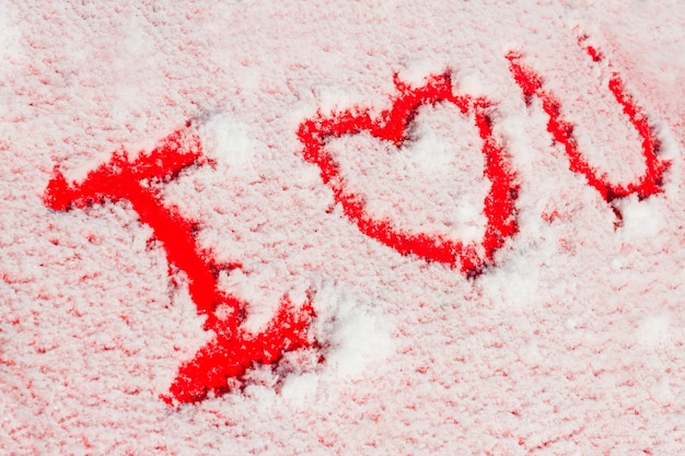 Words I love you on snow covered red car. Romantic concept for Valentine's Day