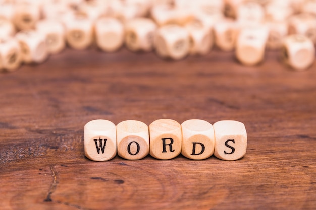 Words letter made with wooden cubes over brown desk