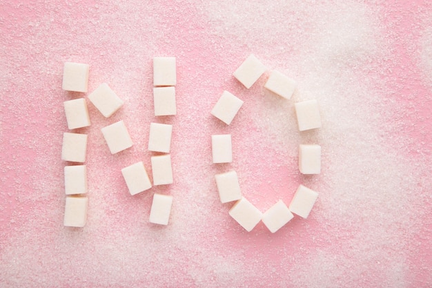 Words no sugar written with sugar on a pink background