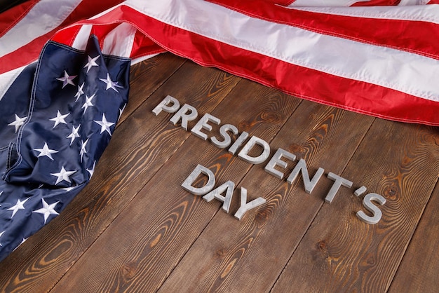 Photo words presitdents day laid with silver letters on wooden surface near us flag