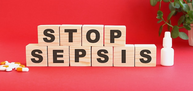 The words STOP SEPSIS is made of wooden cubes on a red background