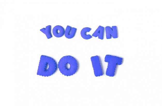 The words YOU CAN DO IT spelled with blue alphabet cookies on white background