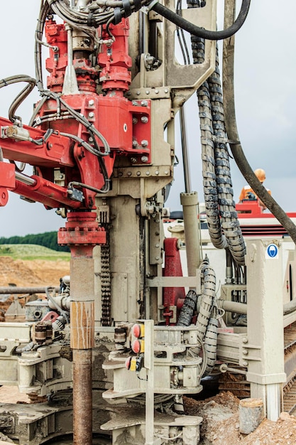 Photo work of a drilling rig at a construction site against a background of blue sky exploration of useful minerals industry and construction