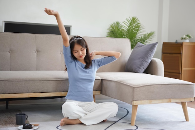 Work from home concept Business women sit on floor and stretching to relax after working at home