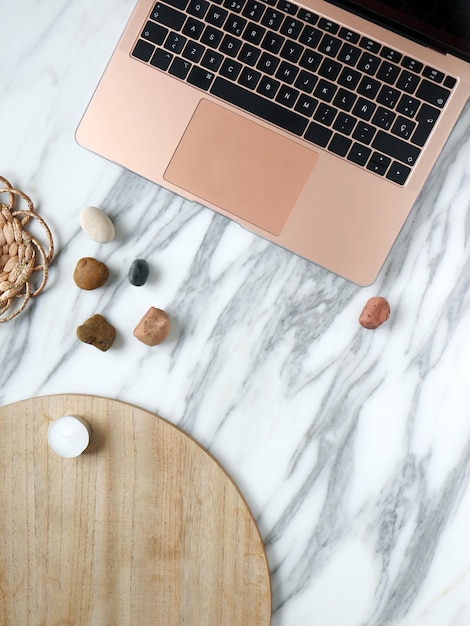 Work from home desk creative office with laptop marble wood and river stones