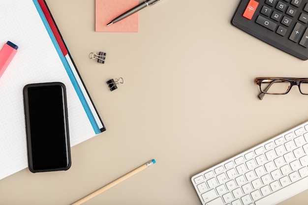 Work at home concept. Desk smart phone, keyboard and office supplies. Copy space