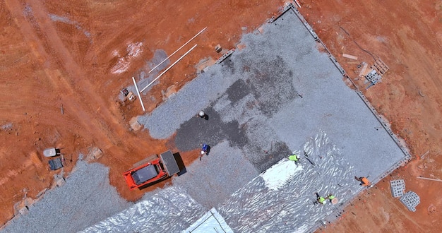 Work on leveling gravel on construction site with an excavator before preparing pouring concrete on the building foundation