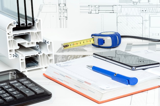 Work space table with notepad, pen, tape measure, calculator,