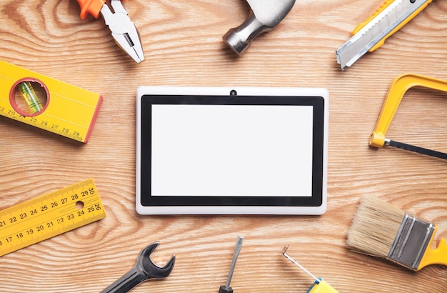 Work tools with tablet on wooden background. Empty screen for your text